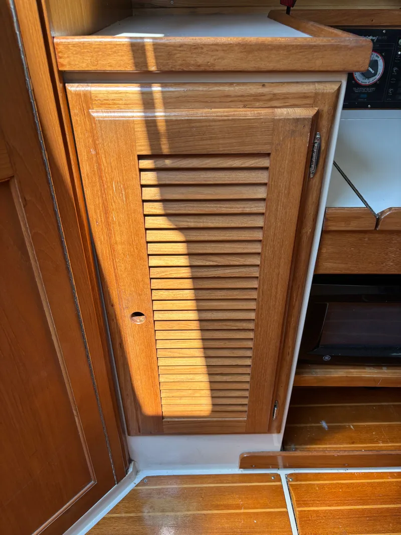 Slide: The Image of Wooden cabinet door inside a 1992 Catalina 34 sailboat, featuring slatted design and natural finish. - 46