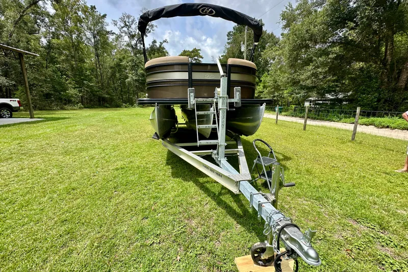 Slide: The Image of 2022 Harris FloteBote 230 Super Sunliner LX on trailer, parked on grassy area. - 10