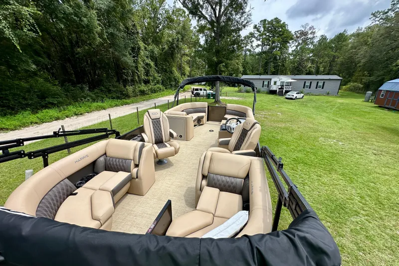 Slide: The Image of 2022 Harris FloteBote 230 Super Sunliner LX pontoon boat with luxurious seating on grassy area. - 20