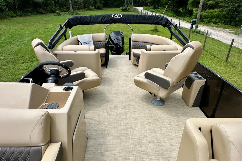 Slide: The Image of 2022 Harris FloteBote 230 Super Sunliner LX pontoon boat with luxurious seating and steering wheel. - 23