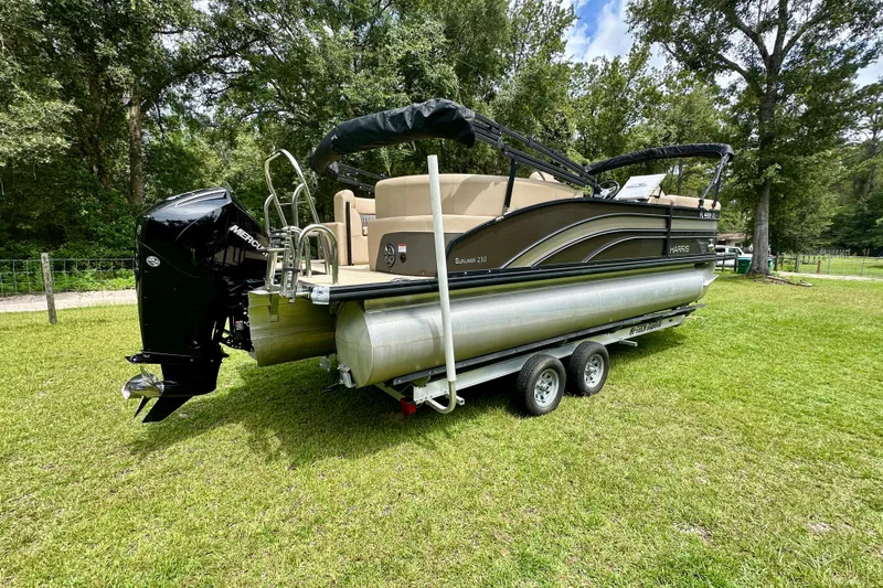 Slide: The Image of 2022 Harris FloteBote 230 Super Sunliner LX pontoon boat on a grassy field. - 3