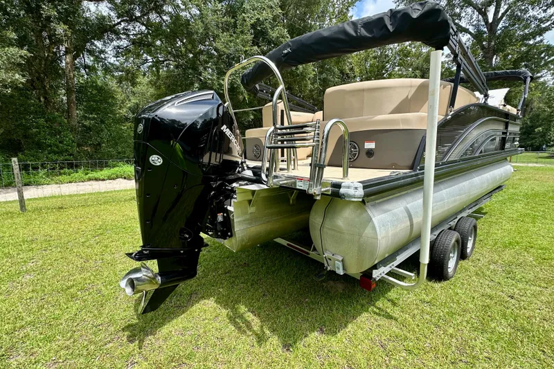 Slide: The Image of 2022 Harris FloteBote 230 Super Sunliner LX pontoon boat on trailer, grassy background. - 4