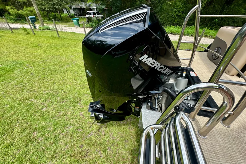 Slide: The Image of 2022 Harris FloteBote 230 Super Sunliner LX with Mercury outboard engine on grassy area. - 44