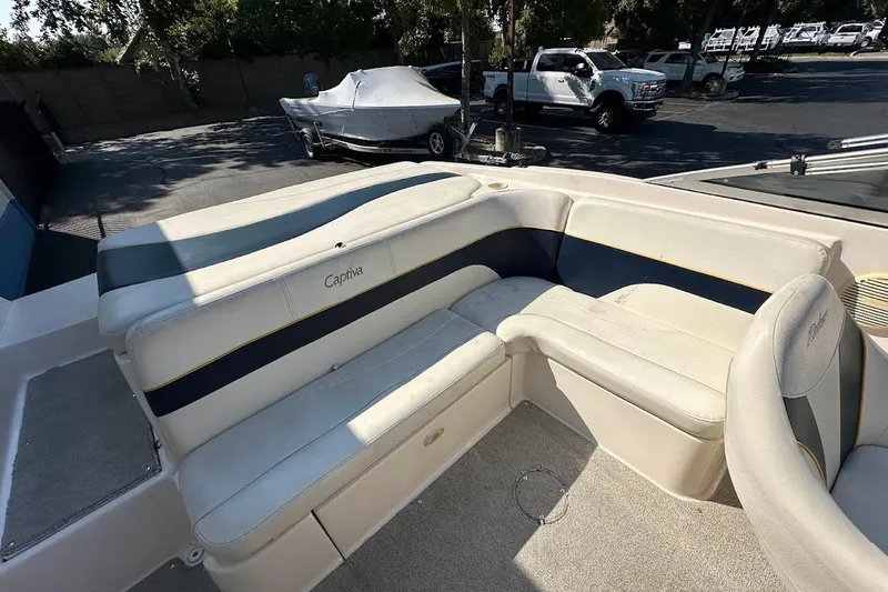 Slide: The Image of 2002 Rinker 212 Captiva boat interior with beige seating and Captiva branding. - 14