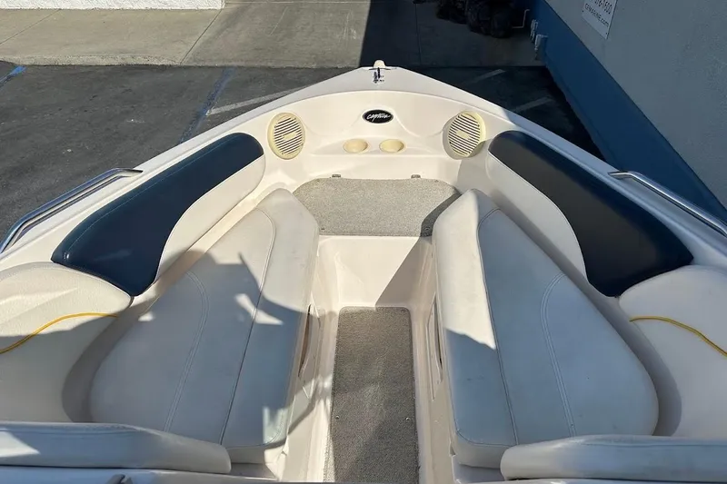 Slide: The Image of 2002 Rinker 212 Captiva boat interior with cushioned seating and speakers. - 21