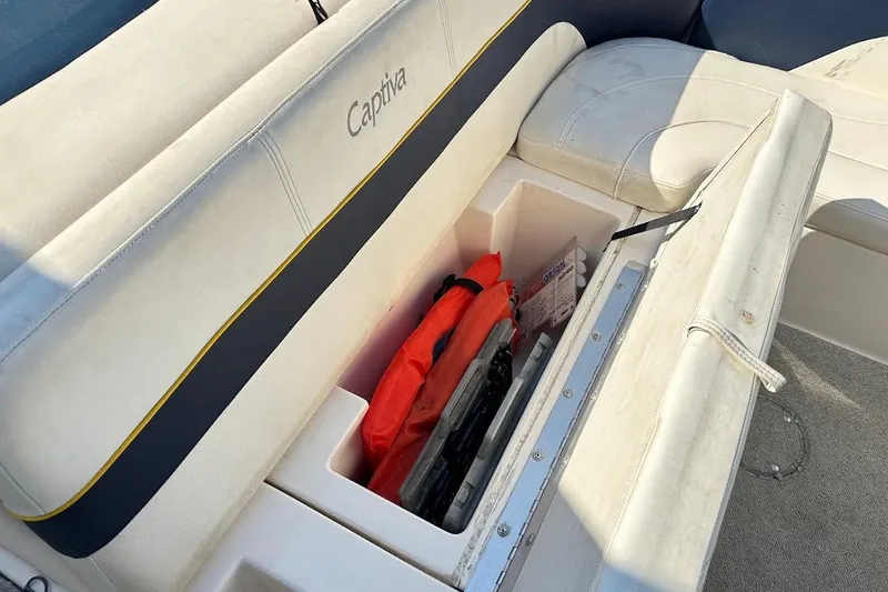 Slide: The Image of 2002 Rinker 212 Captiva boat seat storage with life jacket and accessories. - 23
