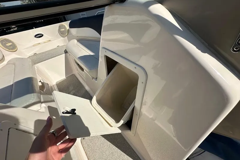 Slide: The Image of 2002 Rinker 212 Captiva boat interior with open storage compartment and seating area. - 26
