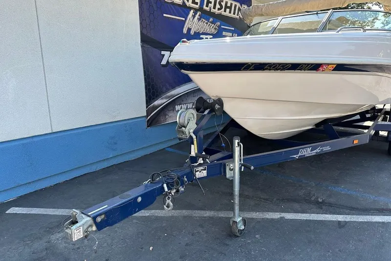 Slide: The Image of 2002 Rinker 212 Captiva boat on trailer, parked outdoors. - 4