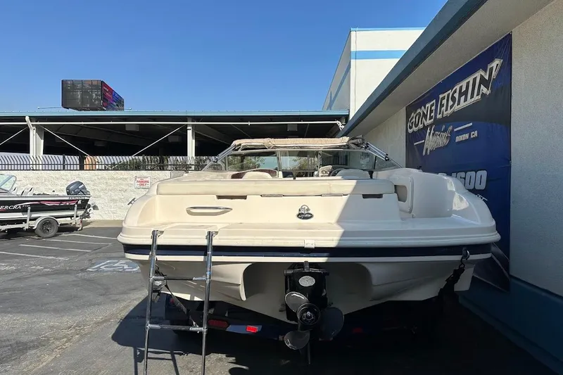 Slide: The Image of 2002 Rinker 212 Captiva boat parked at dealership with ladder and propeller visible. - 7