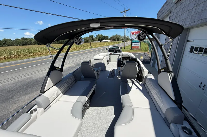 Slide: The Image of 2026 Avalon 2585 Excalibur LTD boat with quad lounger and windshield, parked roadside. - 27
