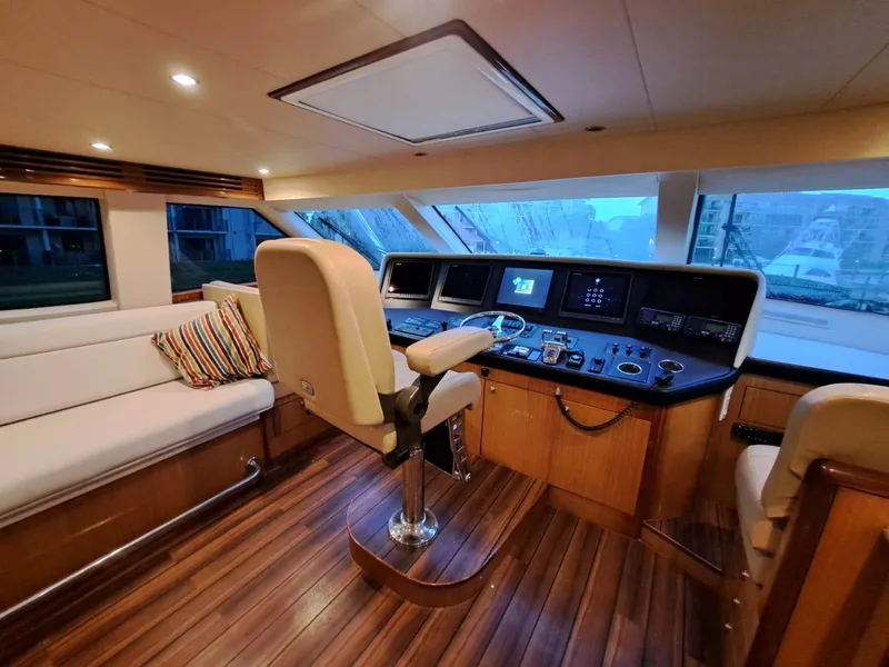 Slide: The Image of Luxurious 2006 Hatteras 68 Convertible yacht interior with plush seating and modern helm. - 20