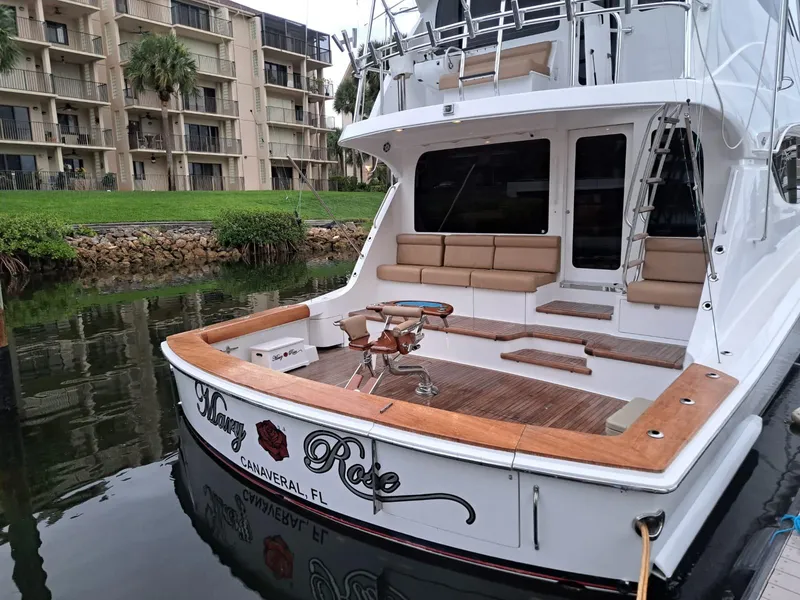 Slide: The Image of 2006 Hatteras 68 Convertible yacht docked in marina, surrounded by waterfront buildings. - 3