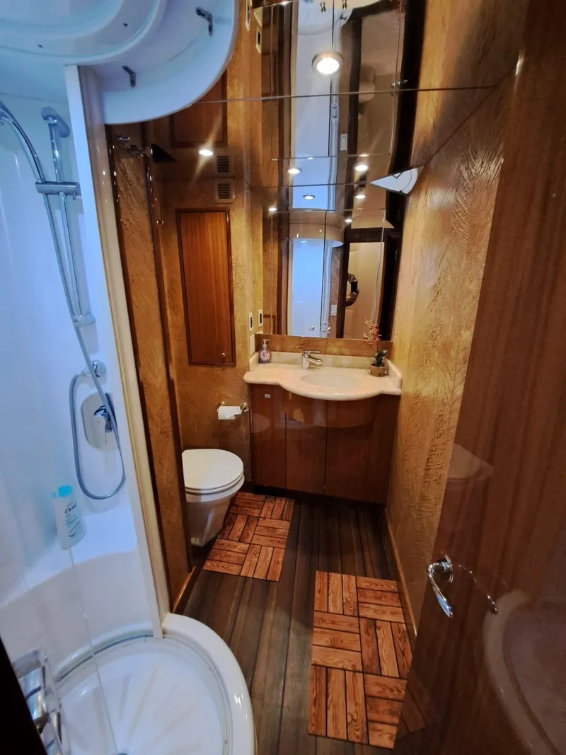 Slide: The Image of Interior staircase of 2006 Hatteras 68 Convertible yacht, featuring elegant wood paneling. - 38