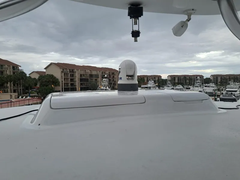 Slide: The Image of 2006 Hatteras 68 Convertible yacht docked in a marina with surrounding buildings. - 42