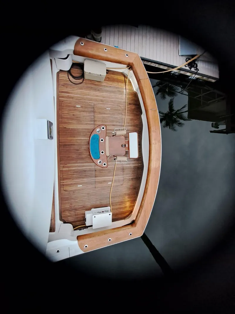 Slide: The Image of 2006 Hatteras 68 Convertible yacht deck with seating and ladder, docked near waterfront buildings. - 46