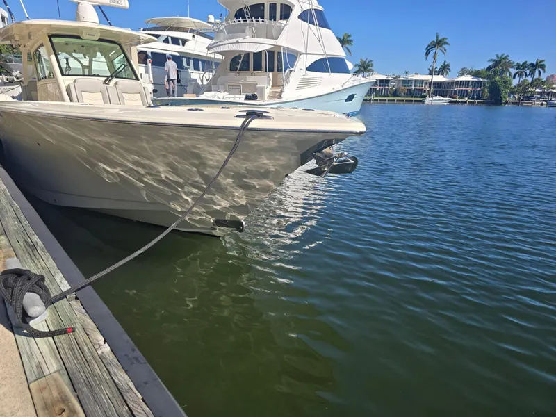 Slide: The Image of 2024 Scout 355 LXF boat docked in a marina with clear blue skies. - 12