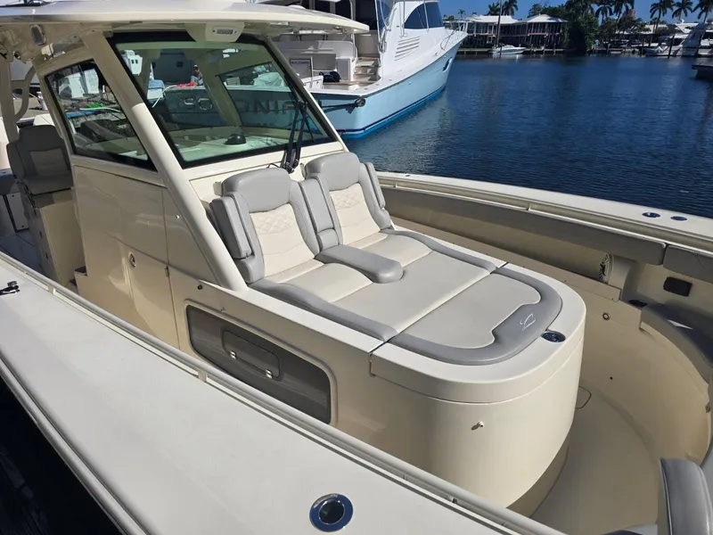 Slide: The Image of 2024 Scout 355 LXF luxury boat with sleek design, docked in marina. - 15