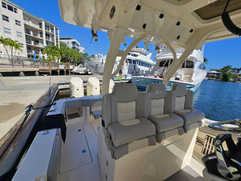Slide: The Image of 2024 Scout 355 LXF boat docked, featuring luxurious seating and modern design. - 17
