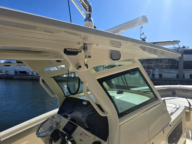 Slide: The Image of 2024 Scout 355 LXF boat helm with modern controls and sleek design, docked by the water. - 21