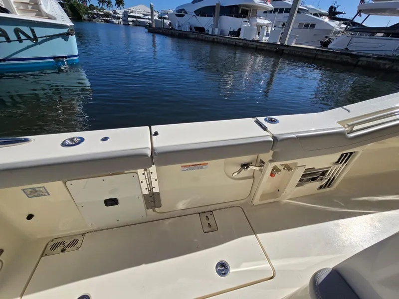 Slide: The Image of 2024 Scout 355 LXF boat interior, docked in a marina with yachts in the background. - 24