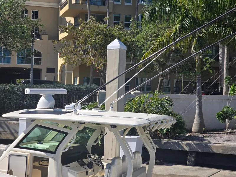 Slide: The Image of 2024 Scout 355 LXF boat docked near palm trees and buildings. - 25