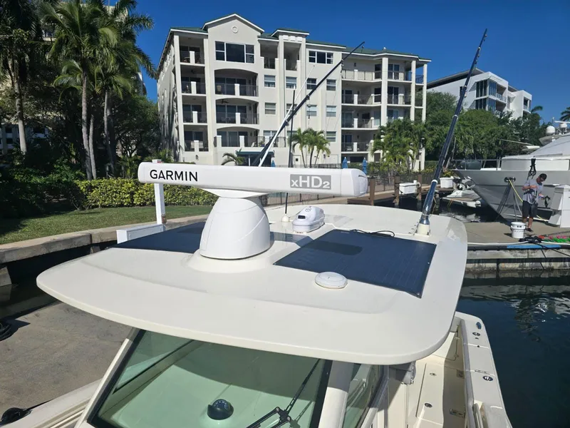 Slide: The Image of 2024 Scout 355 LXF boat docked, featuring Garmin xHD2 radar, with waterfront apartments in the background. - 26