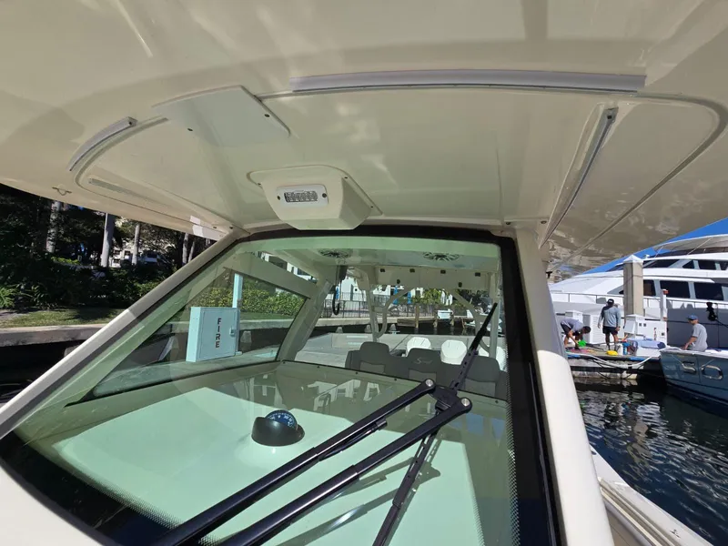Slide: The Image of 2024 Scout 355 LXF boat windshield and cockpit view at marina. - 27