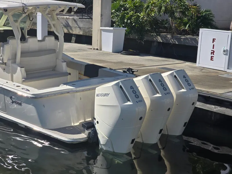 Slide: The Image of 2024 Scout 355 LXF boat with triple Mercury V8 engines docked at marina. - 3