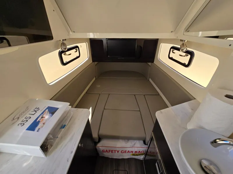 Slide: The Image of 2024 Scout 355 LXF cabin interior with bed, windows, and safety gear bag. - 30