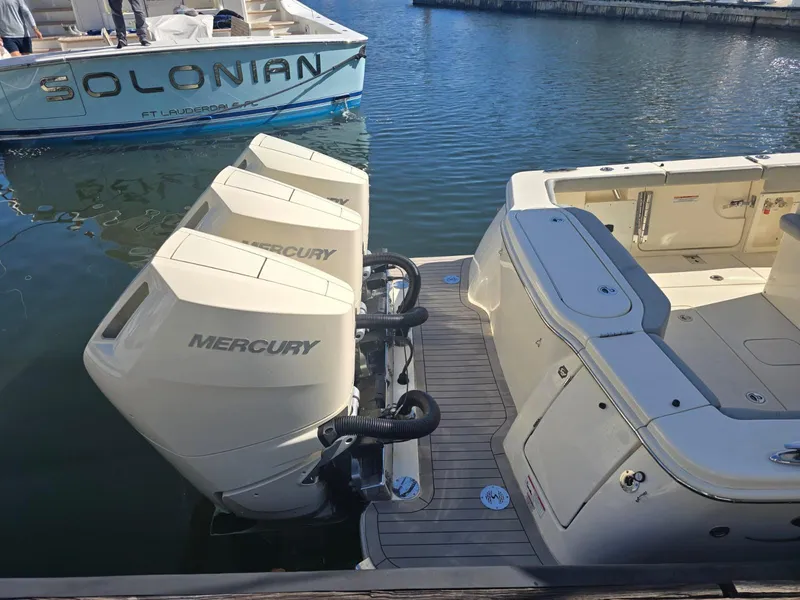 Slide: The Image of 2024 Scout 355 LXF boat with triple Mercury outboard engines docked in marina. - 5