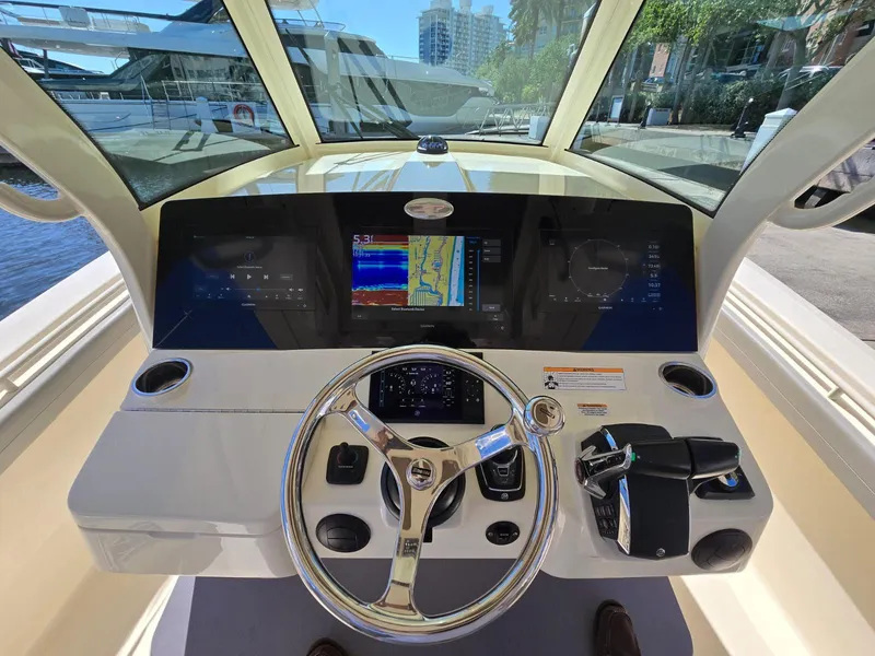 Slide: The Image of 2024 Scout 355 LXF boat dashboard with steering wheel and navigation screens. - 6