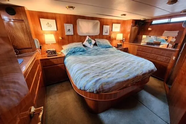 Slide: The Image of Luxurious bedroom in 2000 Novatec Cockpit Motor Yacht with wood paneling and cozy lighting. - 11