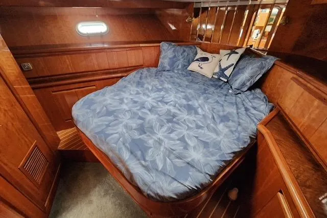 Slide: The Image of Cozy bedroom in 2000 Novatec Cockpit Motor Yacht with blue bedding and wooden interior. - 13