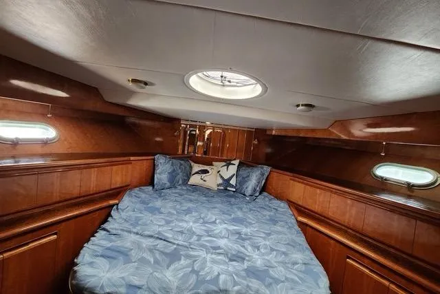 Slide: The Image of Cozy cabin interior of 2000 Novatec Cockpit Motor Yacht with blue bedding and wood paneling. - 14