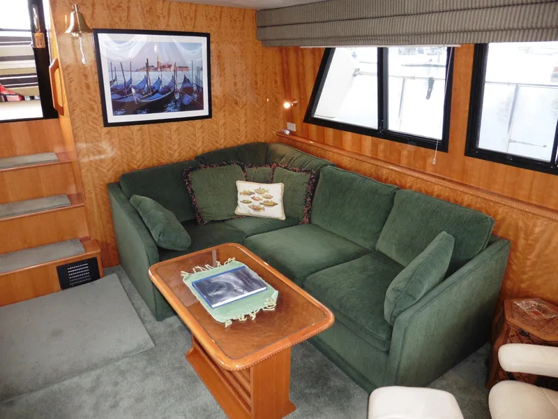 Slide: The Image of Luxurious 2000 Novatec Cockpit Motor Yacht interior with green sofa and wooden accents. - 2
