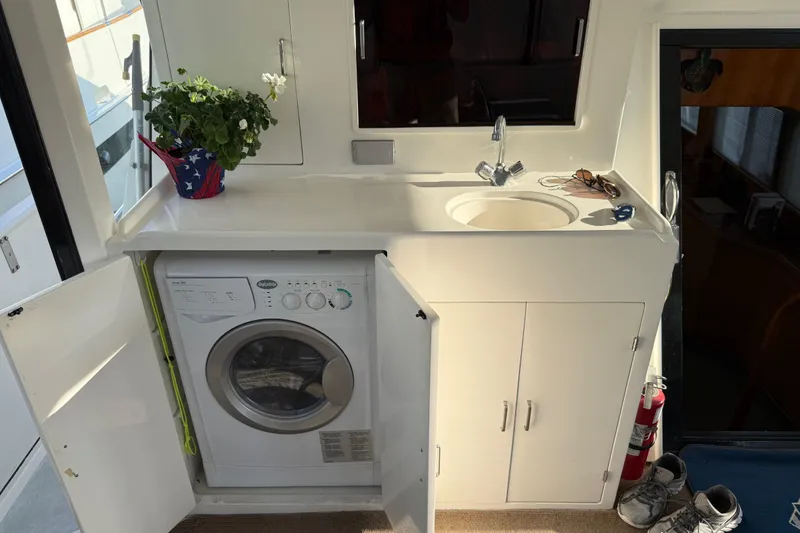 Slide: The Image of 2000 Novatec Cockpit Motor Yacht interior with sink, washing machine, and potted plant. - 42