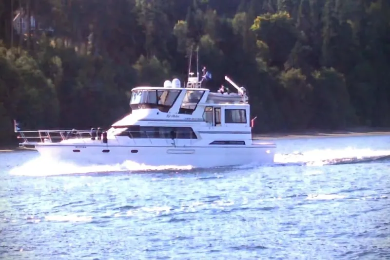 Slide: The Image of Novatec Cockpit Motor Yacht 2000 cruising on a serene lake with forested background. - 71