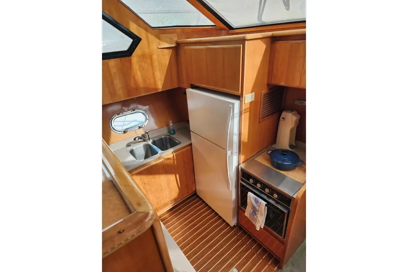 Slide: The Image of Interior of 2000 Novatec Cockpit Motor Yacht kitchen with wood finish and modern appliances. - 8