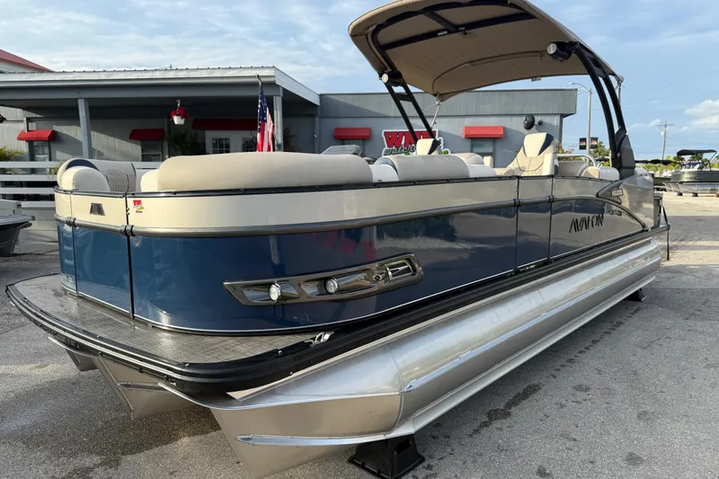 The Image of 2026 Avalon 2385 Catalina Quad Lounger Tri Toon boat, blue and beige, docked outdoors. - 0