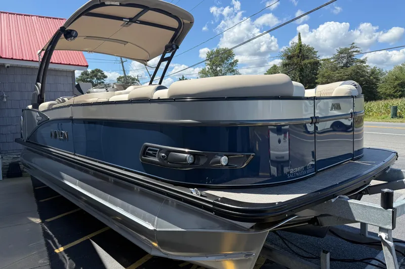 Slide: The Image of 2026 Avalon 2385 Catalina Quad Lounger Tri Toon with American flag, parked outdoors. - 8