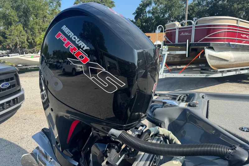 Slide: The Image of 2021 Bass Cat Margay with Mercury Pro XS engine, parked near pontoon boat. - 18