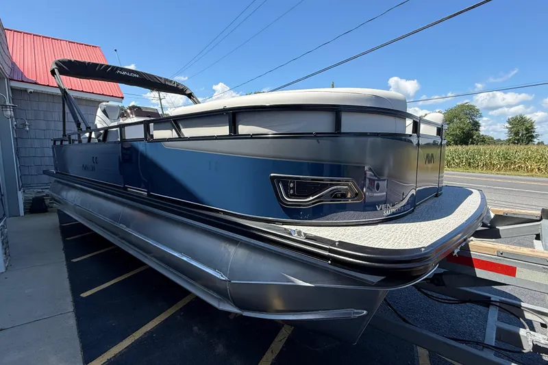Slide: The Image of 2025 Avalon 2385 Venture 85 Tri Toon boat parked on a trailer, side view. - 10