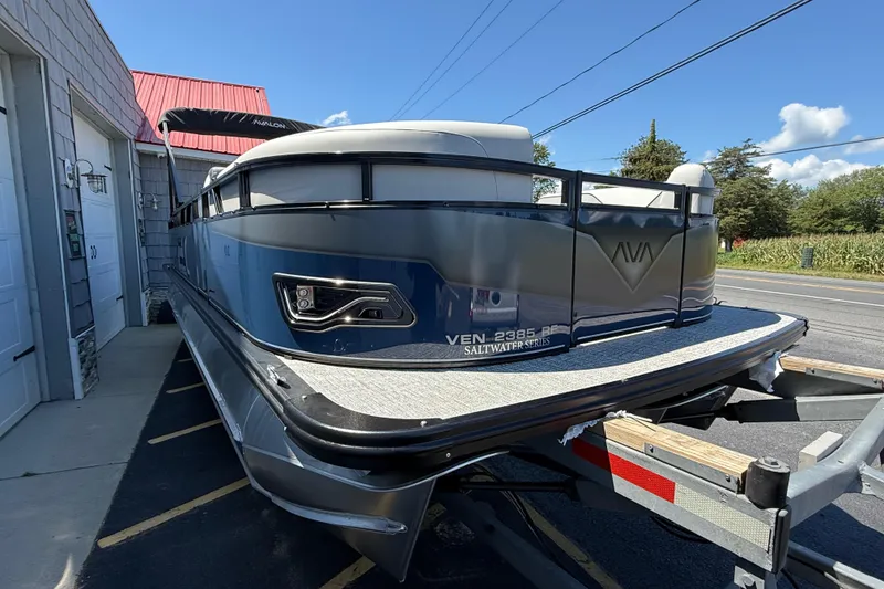 Slide: The Image of 2025 Avalon 2385 Venture Tri Toon boat on trailer, parked outside building. - 11