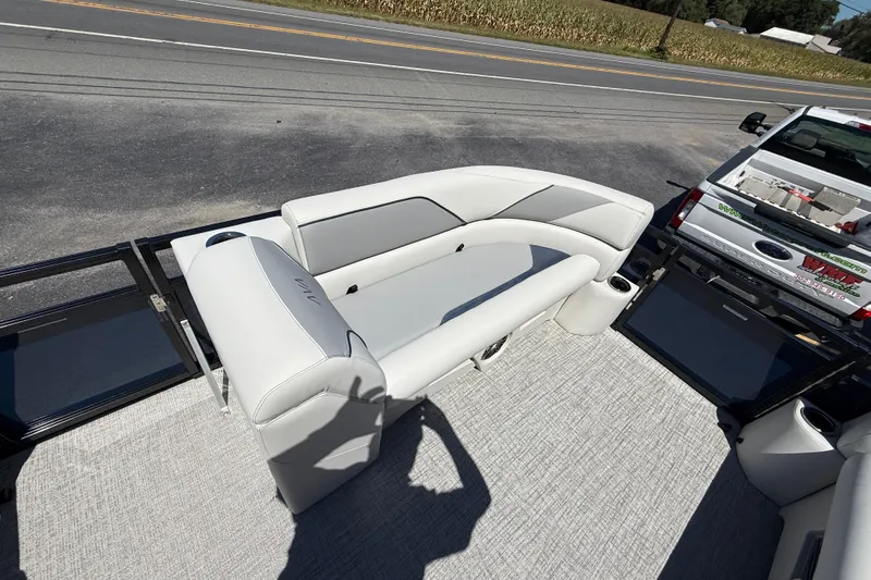 Slide: The Image of 2025 Avalon 2385 Venture 85 Tri Toon boat with rear fishing seat, parked on road. - 16