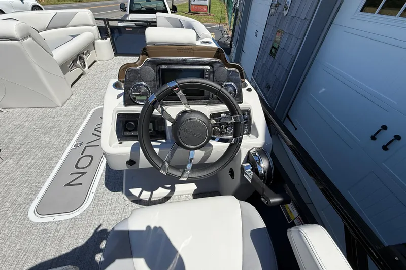Slide: The Image of 2025 Avalon 2385 Venture 85 Tri Toon boat interior with steering console and seating. - 23