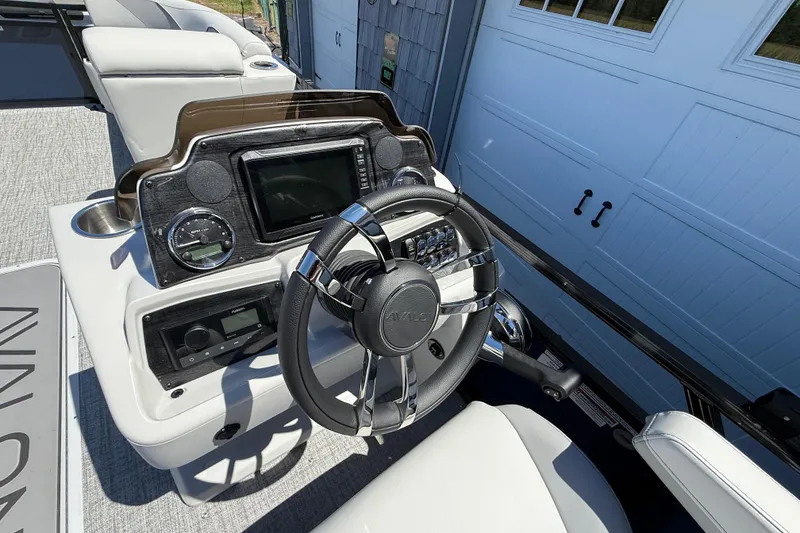 Slide: The Image of 2025 Avalon 2385 Venture 85 boat dashboard with steering wheel and control panel. - 24