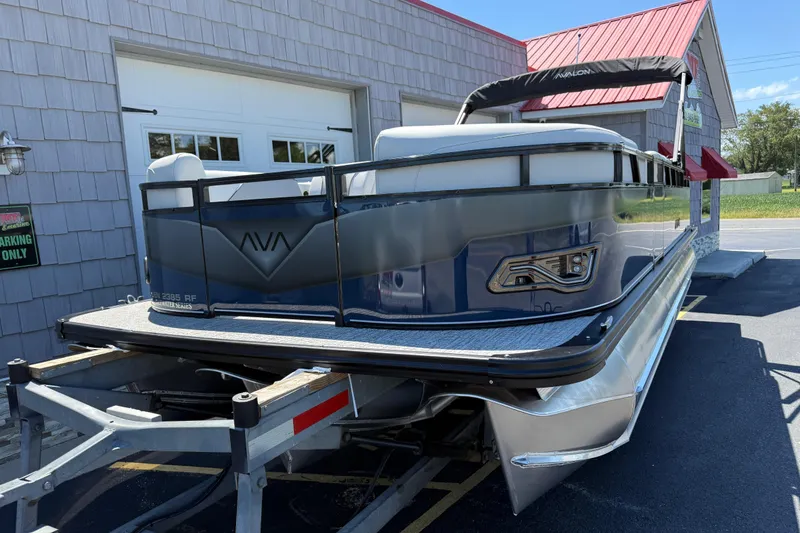 Slide: The Image of 2025 Avalon 2385 Venture 85 Tri Toon boat on trailer, parked outside building. - 4