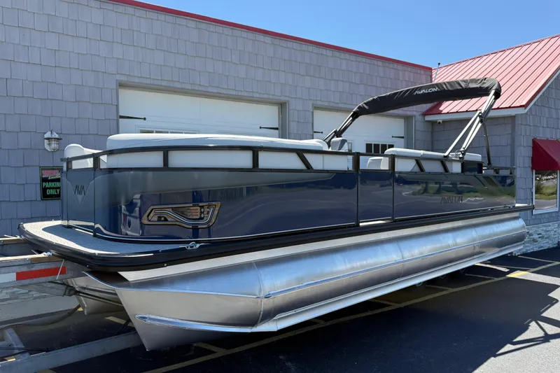 Slide: The Image of 2025 Avalon 2385 Venture 85 Tri Toon boat, high performance, parked outside a building. - 5