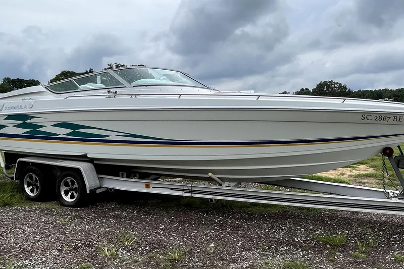 Slide: The Image of 1999 Formula 271 FASTech boat on trailer, white with green and yellow accents. - 1