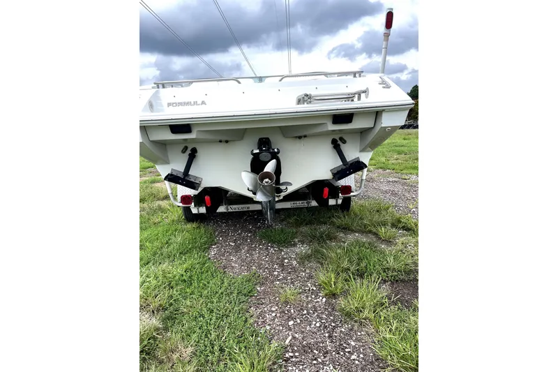 Slide: The Image of 1999 Formula 271 FASTech boat rear view on grassy terrain under cloudy sky. - 12